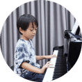 bé trai tự tin chơi piano trước lớp