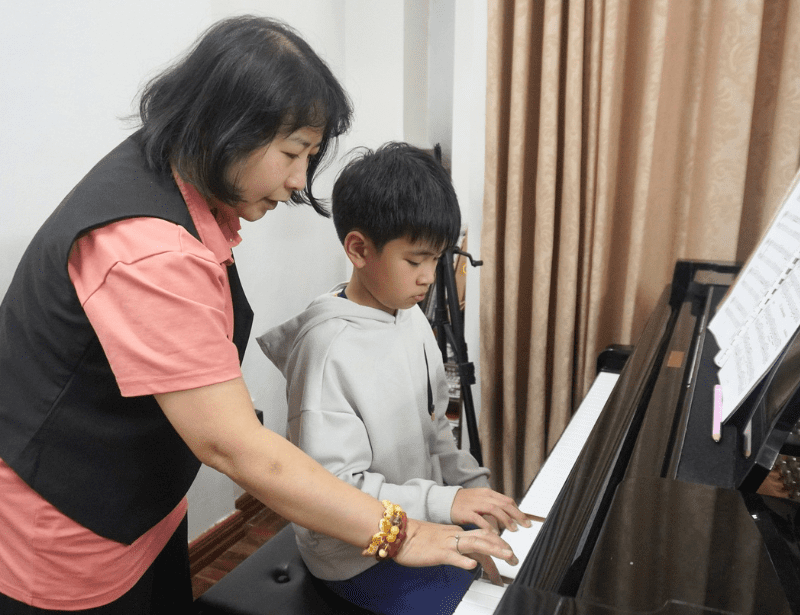 Coach và học viên miệt mài bên cây đàn piano