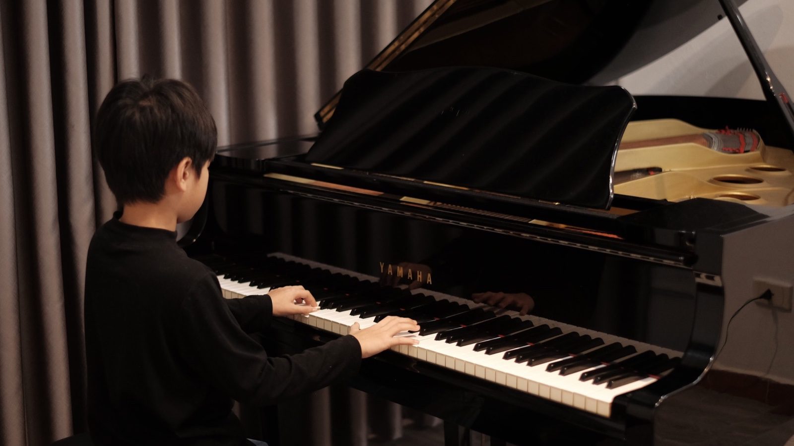 Trẻ ngồi học piano, rèn sự tập trung tại LAM ZONE