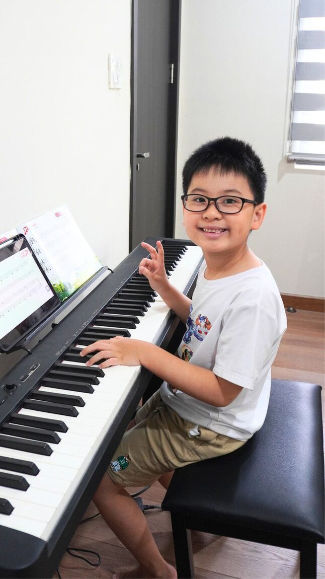 Học viên cười rạng rỡ bên đàn piano