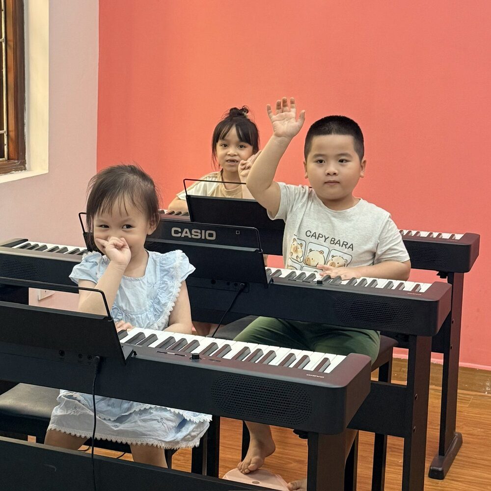 Học viên nhỏ vẫy tay chào trong lớp piano